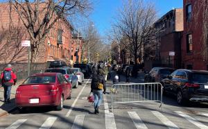 People walking their bikes through barricades in the street