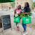 Smiling shoppers holding produce and carrying in reusable bags